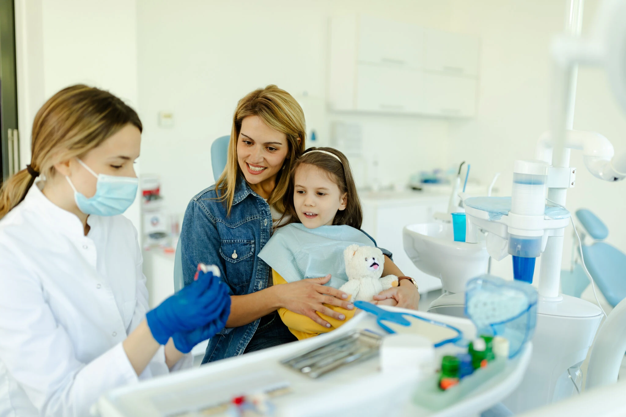 happy mother and child seeing pediatric dentist