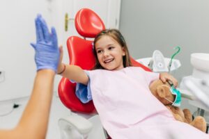 little girl giving a high-five to her dentist